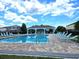 Community pool featuring lounge chairs, shade, and a beautiful paver deck offer residents an oasis at 12121 Tree Haven Ave, Gibsonton, FL 33534