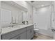 Bathroom featuring gray cabinets, granite countertops, shower/tub combo, and sleek fixtures at 12277 Spring Hill Dr, Spring Hill, FL 34609