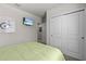 Cozy bedroom featuring a green bed, sliding closet doors and a wall-mounted TV at 12277 Spring Hill Dr, Spring Hill, FL 34609