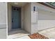 A close up shot of the front door and three car garage with a well manicured small garden at 12277 Spring Hill Dr, Spring Hill, FL 34609