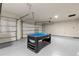 Spacious garage featuring an epoxy floor, ping pong table and ample garage door access at 12277 Spring Hill Dr, Spring Hill, FL 34609