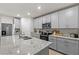 Modern kitchen featuring gray cabinets, stainless steel appliances and a spacious granite countertop island at 12277 Spring Hill Dr, Spring Hill, FL 34609
