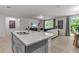 Modern kitchen features a granite countertop island, stainless steel sink, and an open view to the living room at 12277 Spring Hill Dr, Spring Hill, FL 34609