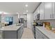 A modern kitchen with gray cabinets, granite countertops, stainless steel appliances, and wood floors at 12277 Spring Hill Dr, Spring Hill, FL 34609