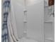 Modern walk-in shower with tiled walls, built-in shelving, and stylish shower curtain at 12277 Spring Hill Dr, Spring Hill, FL 34609