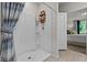 Elegant walk-in shower, built-in shelving, modern fixtures, with an open view into the bedroom at 12277 Spring Hill Dr, Spring Hill, FL 34609