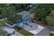 Aerial view of charming light blue two-story home with mature trees, an airy second story balcony, and a white driveway at 132 Pennsylvania Ave, Palm Harbor, FL 34683