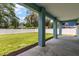 View from covered patio looking out onto the expansive, green backyard enclosed by a white privacy fence at 132 Pennsylvania Ave, Palm Harbor, FL 34683