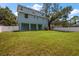 Spacious, fenced backyard featuring lush green grass and the rear of the two-story home with covered patio at 132 Pennsylvania Ave, Palm Harbor, FL 34683