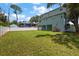 Large backyard with well-manicured lawn, privacy fence and view of the home's rear exterior at 132 Pennsylvania Ave, Palm Harbor, FL 34683