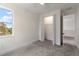 Bedroom with plush carpet, a large window view, and an open closet, illuminated by natural light at 132 Pennsylvania Ave, Palm Harbor, FL 34683