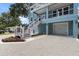 Side exterior view showcasing staircase, the driveway, and garage of the charming home at 132 Pennsylvania Ave, Palm Harbor, FL 34683