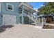 Exterior of the home with garage and stairs to a second level patio, surrounded by manicured landscaping at 132 Pennsylvania Ave, Palm Harbor, FL 34683