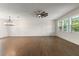 Bright and airy living room with hardwood floors, chandelier, and ample natural light from large windows at 132 Pennsylvania Ave, Palm Harbor, FL 34683