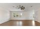 Open living room filled with natural light from multiple windows and a contemporary ceiling fan at 132 Pennsylvania Ave, Palm Harbor, FL 34683