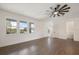 Bright living room features wood-look floors, three windows, and a modern ceiling fan at 132 Pennsylvania Ave, Palm Harbor, FL 34683