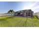 Fenced backyard featuring an enclosed patio with hot tub and landscaped lawn at 1332 Ocean Spray Dr, Ruskin, FL 33570