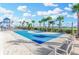 Outdoor blue basketball court surrounded by palm trees and a playground under a partly cloudy bright blue sky at 1332 Ocean Spray Dr, Ruskin, FL 33570
