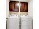 A laundry room featuring a white washer and dryer set, with dark cabinets above at 1332 Ocean Spray Dr, Ruskin, FL 33570