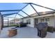 Relaxing screened patio with grill, fire pit, and sliding doors to interior at 1332 Ocean Spray Dr, Ruskin, FL 33570