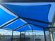 Backyard patio cover with bright blue sunshades and a black metal frame at 1332 Ocean Spray Dr, Ruskin, FL 33570