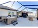 Spacious screened patio with a luxurious hot tub, grill, and fire pit at 1332 Ocean Spray Dr, Ruskin, FL 33570