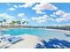 Stunning community pool with lounge chairs, palm trees, and beautiful landscaping in a desirable neighborhood at 1332 Ocean Spray Dr, Ruskin, FL 33570