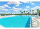 Beautiful community pool with crystal clear water, lounge chairs, and a playground in the background at 1332 Ocean Spray Dr, Ruskin, FL 33570