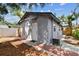 Home's backyard features a wooden deck, gray exterior and is surrounded by greenery and a brick walkway at 1510 W Powhatan Ave, Tampa, FL 33603