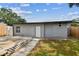 This home's backyard features a wooden deck, gray exterior and is surrounded by a vibrant lawn at 1510 W Powhatan Ave, Tampa, FL 33603
