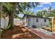 This home's backyard features a mature tree, gray exterior and a brick and concrete walkway at 1510 W Powhatan Ave, Tampa, FL 33603