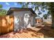 Home's backyard features a wooden deck, gray exterior and is surrounded by a wooden fence and a brick walkway at 1510 W Powhatan Ave, Tampa, FL 33603