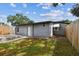 Home's backyard features a wooden deck, a gray exterior and is surrounded by a wooden fence and a vibrant lawn at 1510 W Powhatan Ave, Tampa, FL 33603