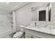 Modern bathroom featuring stylish marble-look shower tiles, a white vanity, and a sleek mirror at 1510 W Powhatan Ave, Tampa, FL 33603
