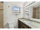 Bathroom featuring granite counters, wood cabinetry, and framed mirror at 1510 W Powhatan Ave, Tampa, FL 33603