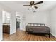 Bedroom featuring wood-look floors, a ceiling fan and open access to both the kitchen and bathroom at 1510 W Powhatan Ave, Tampa, FL 33603