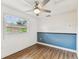 Bedroom featuring vinyl floors, ceiling fan, and updated white and blue walls at 1510 W Powhatan Ave, Tampa, FL 33603