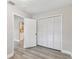 Bedroom with wood-look flooring, a closet, and an open doorway at 1510 W Powhatan Ave, Tampa, FL 33603
