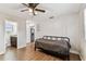Bedroom featuring wood-look floors, a ceiling fan and open access to both the kitchen and bathroom at 1510 W Powhatan Ave, Tampa, FL 33603