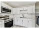 Well-lit kitchen featuring white cabinets, modern appliances, and a clean, stylish design at 1510 W Powhatan Ave, Tampa, FL 33603