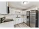 Updated kitchen with stainless steel appliances, white cabinets and countertops, and gray wood-look floors at 1510 W Powhatan Ave, Tampa, FL 33603