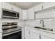 Modern kitchen with sleek appliances, white cabinetry, and granite countertops at 1510 W Powhatan Ave, Tampa, FL 33603