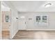 Bright living room featuring wood-look flooring, two windows, and a white front door at 1510 W Powhatan Ave, Tampa, FL 33603