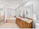 Bright bathroom featuring double sinks, a bathtub, a glass shower, and natural light at 1731 W Watrous Ave # 202, Tampa, FL 33606
