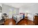 Cozy bedroom featuring hardwood floors, natural light, a full bed, and stylish décor at 1731 W Watrous Ave # 202, Tampa, FL 33606