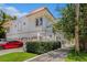 Elegant home exterior featuring a red tile roof, lush landscaping, and a red electric vehicle parked in driveway at 1731 W Watrous Ave # 202, Tampa, FL 33606