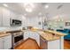 Well-equipped kitchen with stainless steel appliances, granite countertops, white cabinetry, and breakfast bar at 1731 W Watrous Ave # 202, Tampa, FL 33606