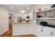 Kitchen with breakfast bar, stainless steel appliances, white cabinetry, open shelves, and hardwood floors at 1731 W Watrous Ave # 202, Tampa, FL 33606