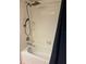 Clean, white bathroom with a shower and tub combination featuring chrome showerhead at 17361 Old Tobacco Rd, Lutz, FL 33558