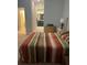 Well-lit bedroom featuring a striped bedspread and access to an ensuite bathroom at 17361 Old Tobacco Rd, Lutz, FL 33558